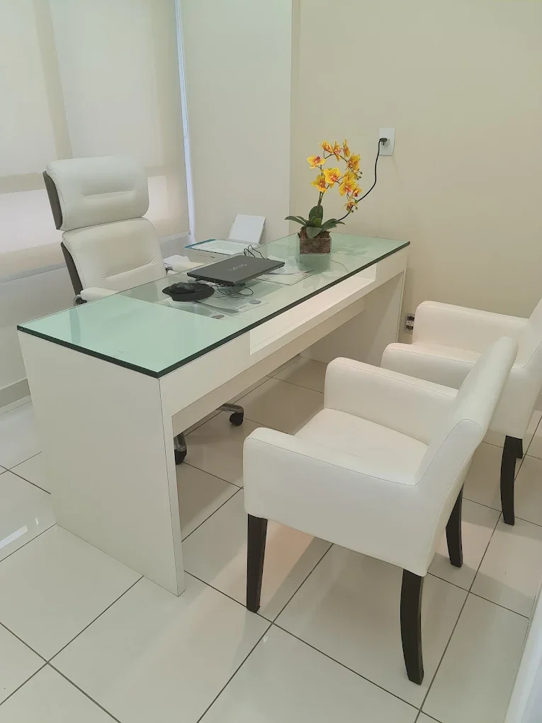 Sala de atendimento da Dra. Cynthia Kane com mesa de vidro e cadeiras