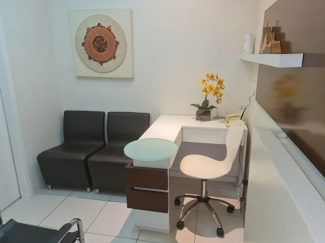 Recepção do consultório com poltronas e arte na parede